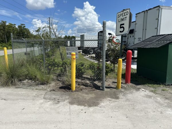 Commercial chain link fence and steel safety bollard repaired after vehicle impact in Orlando, FL.