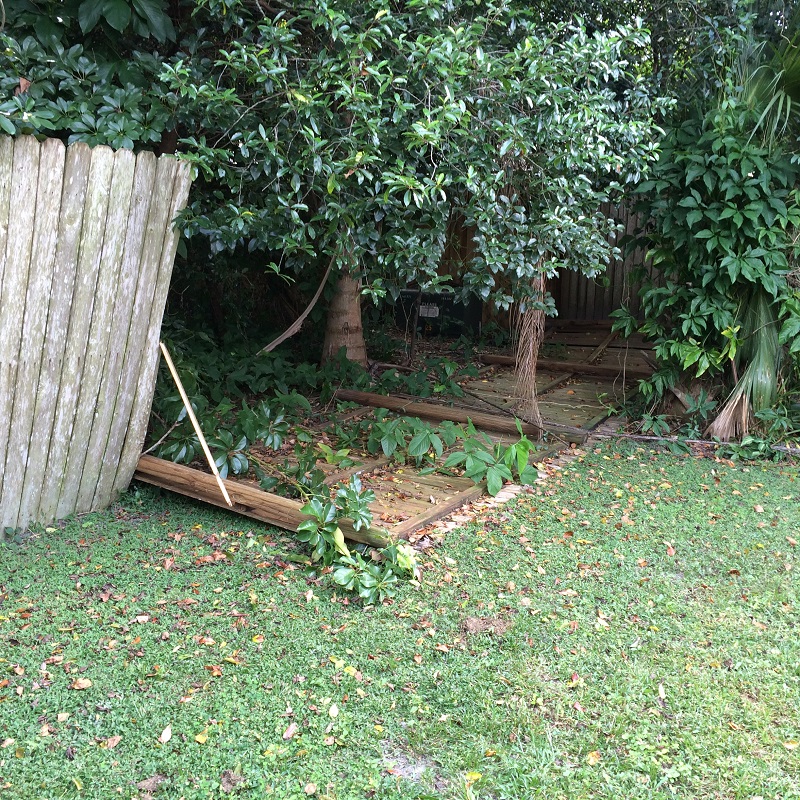 Storm-damaged wood privacy fence with broken posts and fallen panels in Orlando FL
