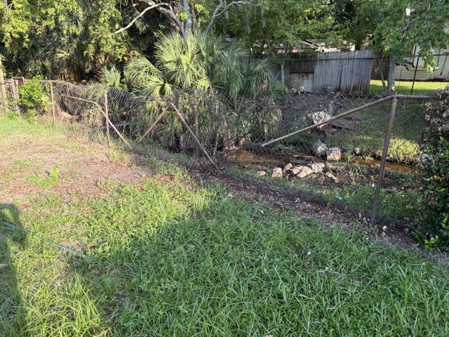 Chain link fence damaged by fallen tree in Titusville FL