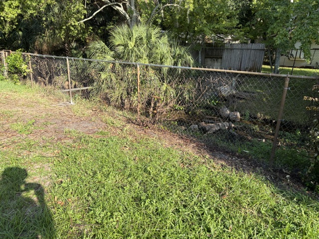 Completed chain link fence repair after tree damage in Titusville FL